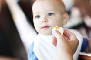 کودک در حال خوردن تخم مرغ